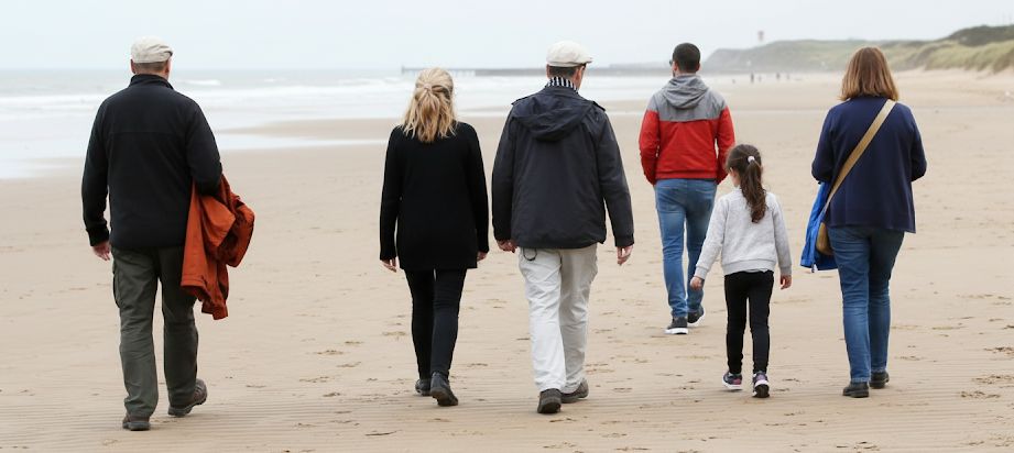Family group on a sandy Lincolnshire beach near their group cottage